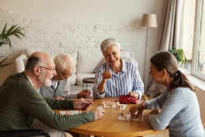 Four people gathered around a table playing a game and laughing together