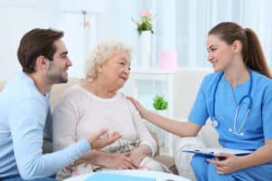 A nurse speaking with a resident and their visitor in a welcoming environment
